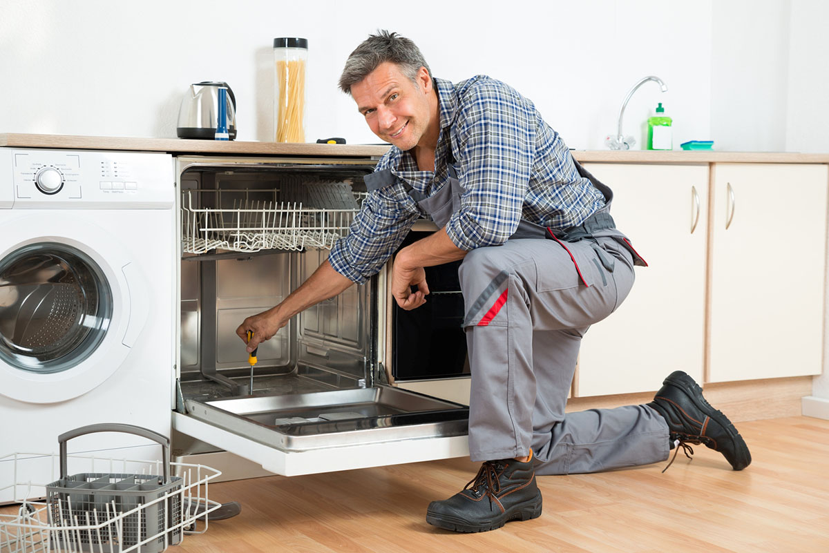 Técnico reparando lavavajillas en cocina
